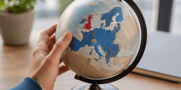 Hand houdt wereldbol vast met focus op Europa en het Verenigd Koninkrijk als symbool voor internationale handel en de impact van de Brexit. Hand houdt wereldbol vast met focus op Europa en het Verenigd Koninkrijk als symbool voor internationale handel en de impact van de Brexit.